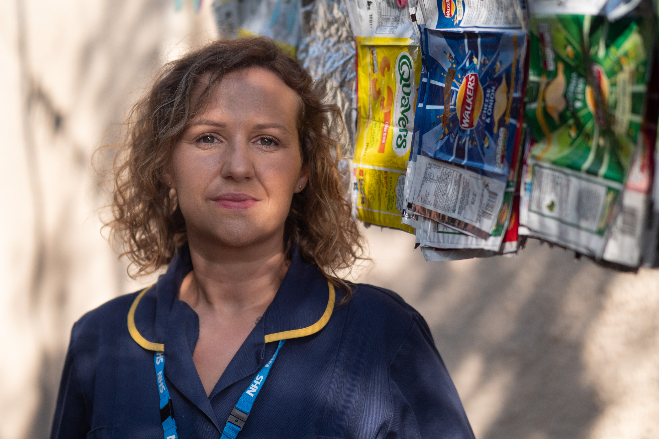 Nurse in front of crisp packets wall