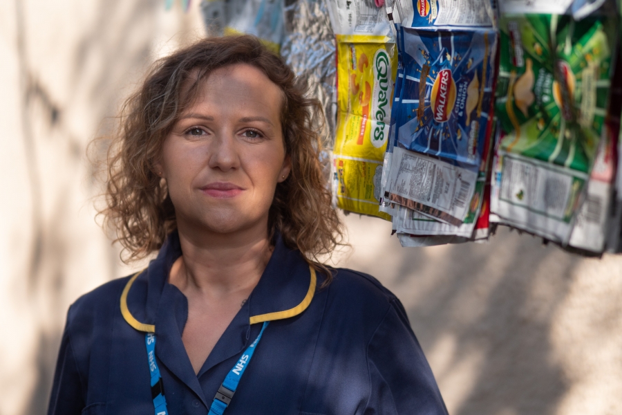 Nurse in front of crisp packets wall